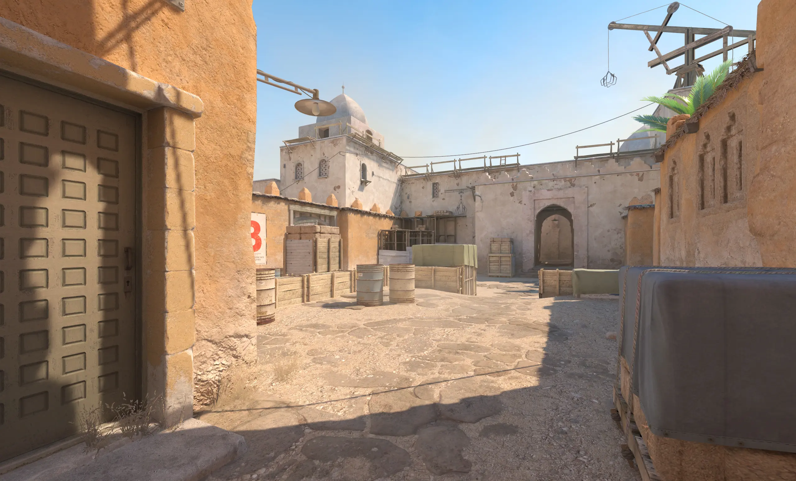 In-game view of the Cache map from CS2 showing buildings and crates.