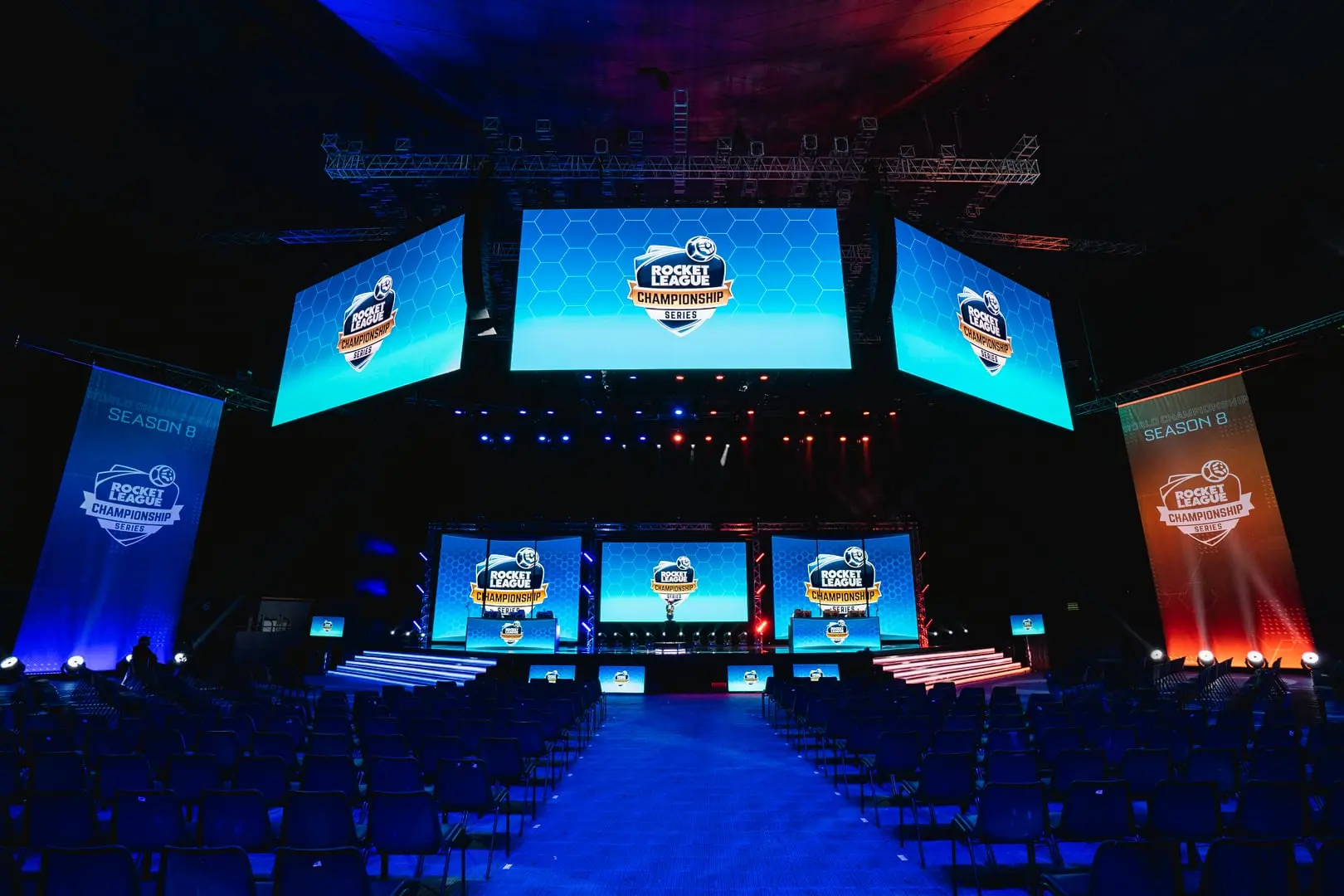Rocket League Championship Series Season 8 arena stage with blue lighting and multiple large screens.