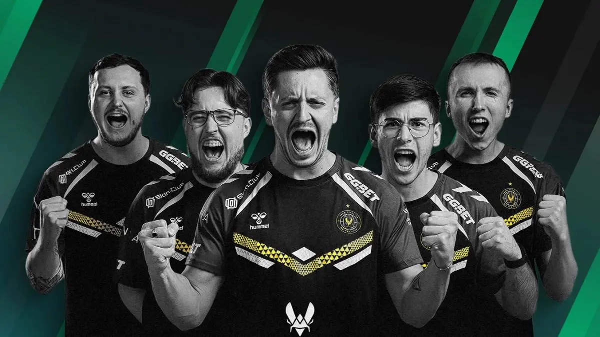 Five members of the Team Vitality esports team shouting and cheering in team jerseys against a green background.