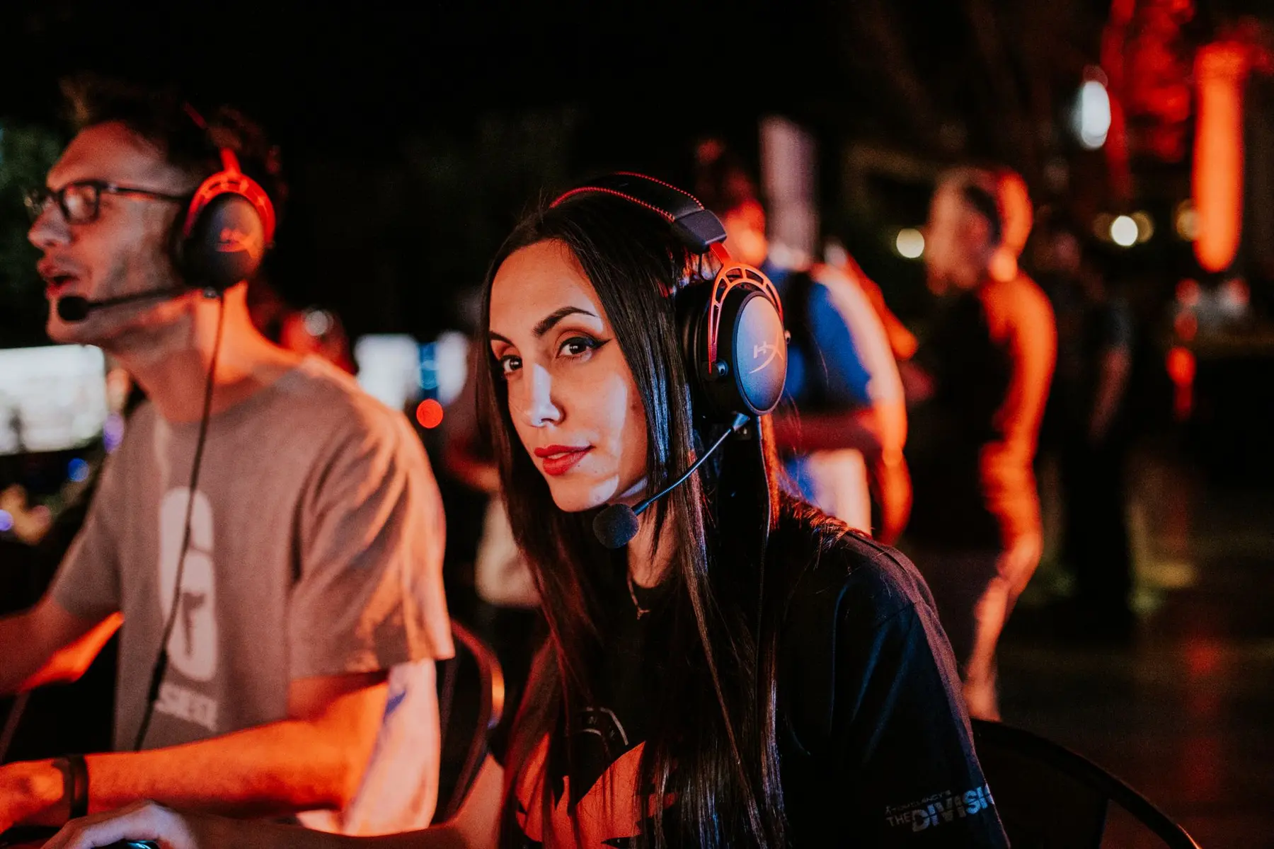 A woman wearing a gaming headset and a The Division branded jersey at an esports event